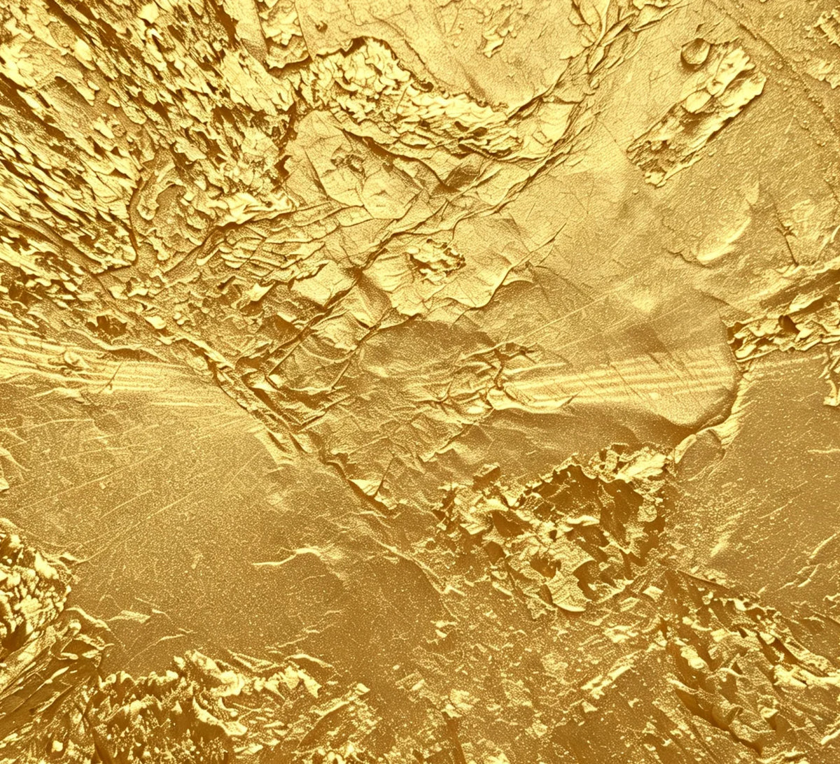 Macro of the hand-applied gold leaf: crumpled, uneven, dimensional