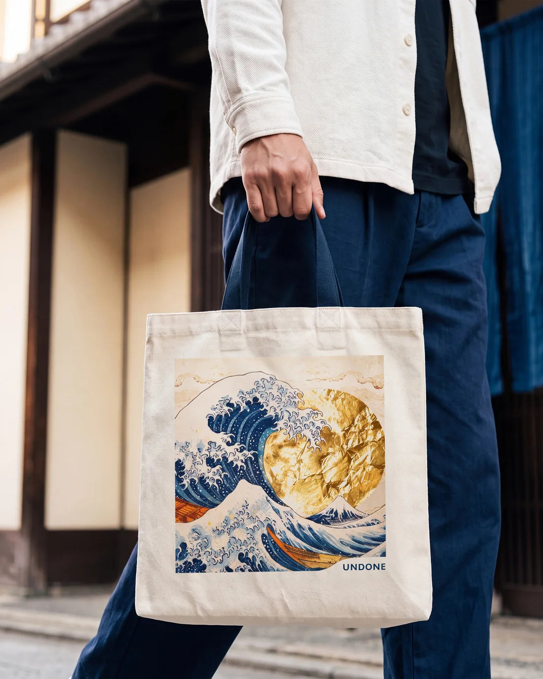 The Hokusai tote bag carried down a street of old wooden houses