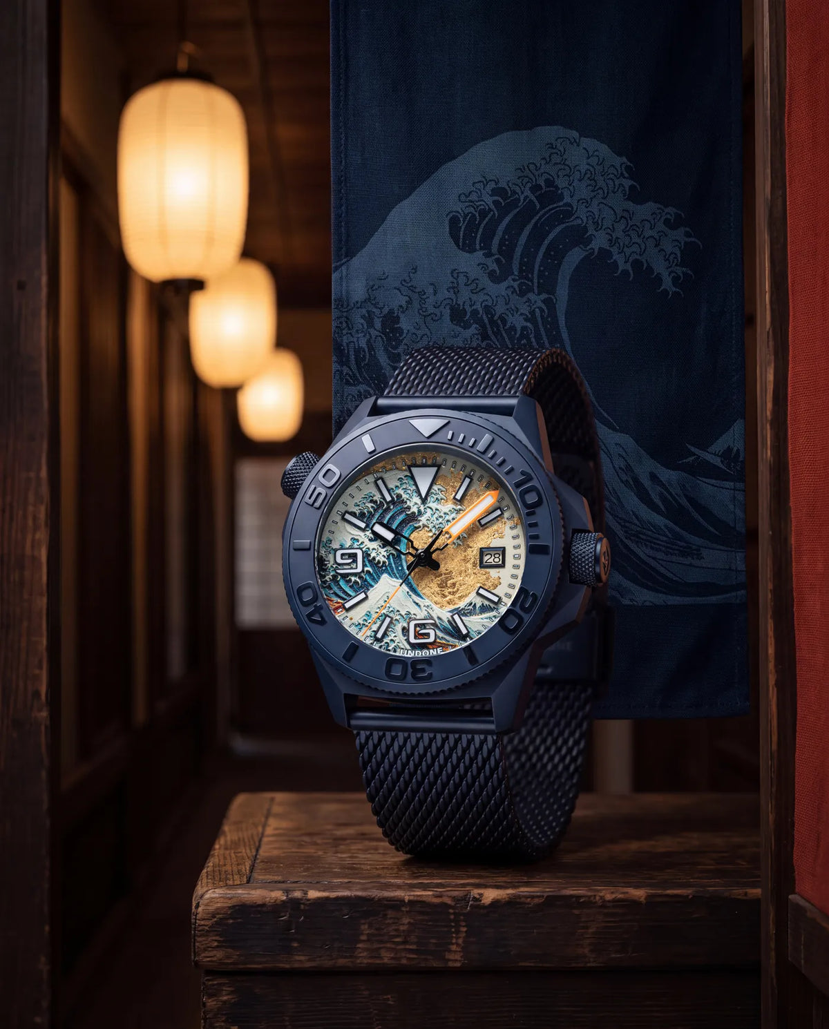 On a wooden stand in a lantern-lit corridor hung with a Great Wave noren