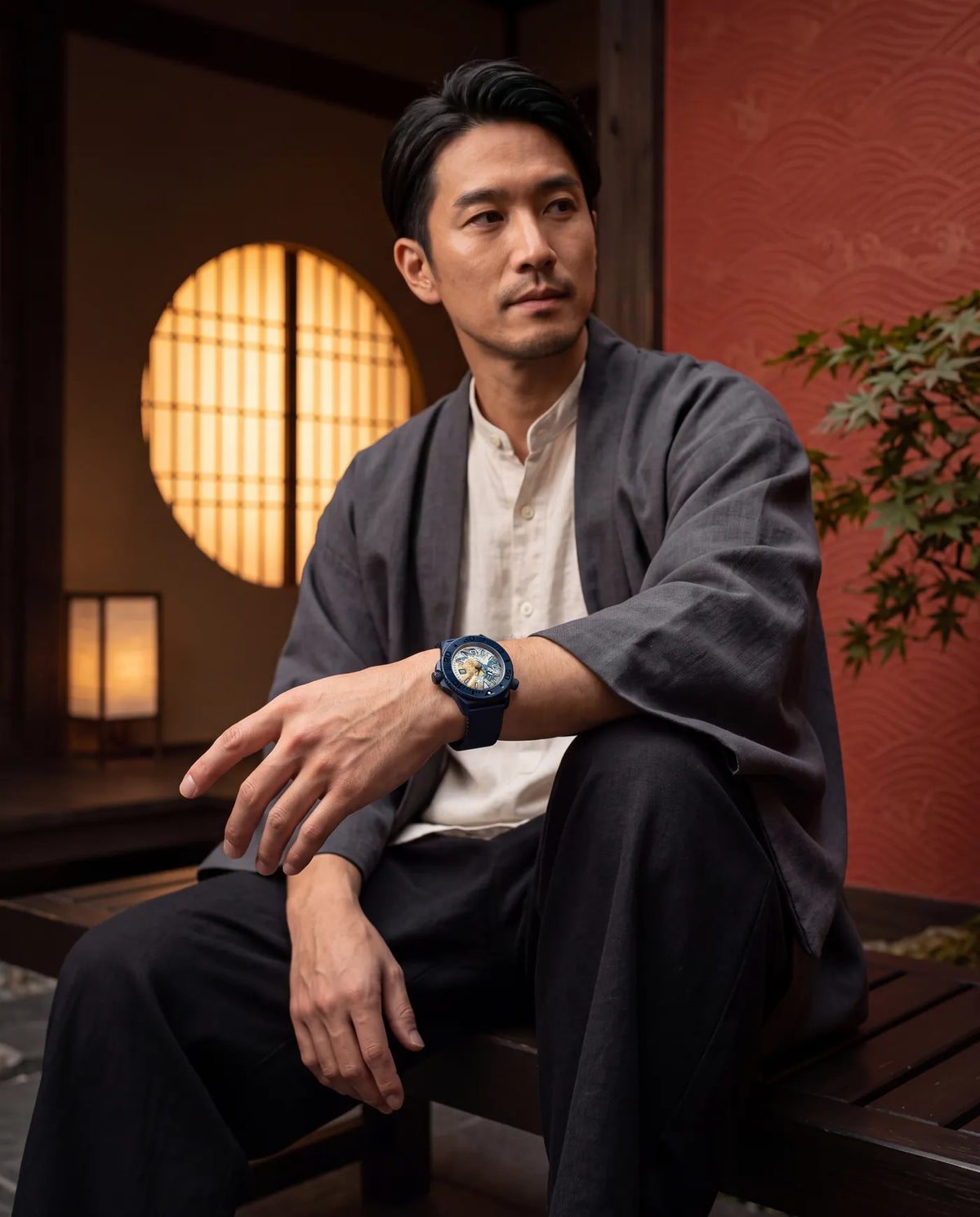 Seated by a lantern-lit round window