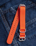 20mm orange NATO watch strap laid on denim